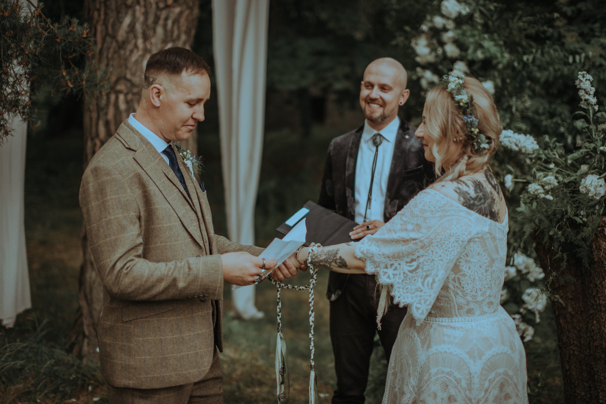 Para młoda trzymająca się za ręce podczas składania przysięgi małżeńskiej
