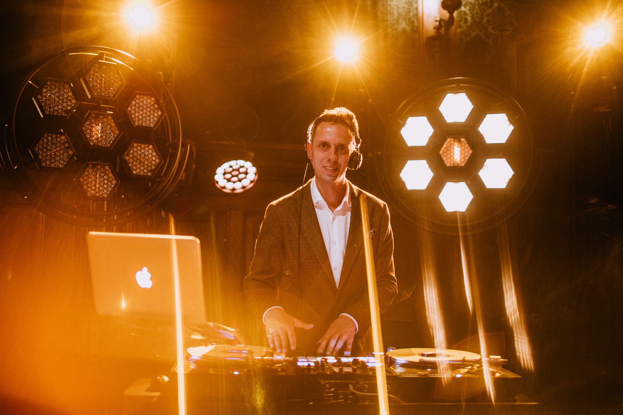 DJ na poprawiny podczas występu w eleganckiej oprawie, z efektownym oświetleniem scenicznym